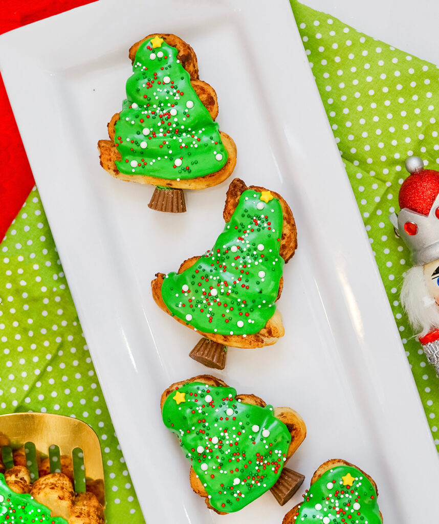 Make Christmas trees out of cinnamon rolls! These Christmas Tree Cinnamon Rolls are the perfect addition to your breakfast Christmas morning. The kids will even have fun decorating their own tree. And how cute are the mini Reese's as the tree trunks!