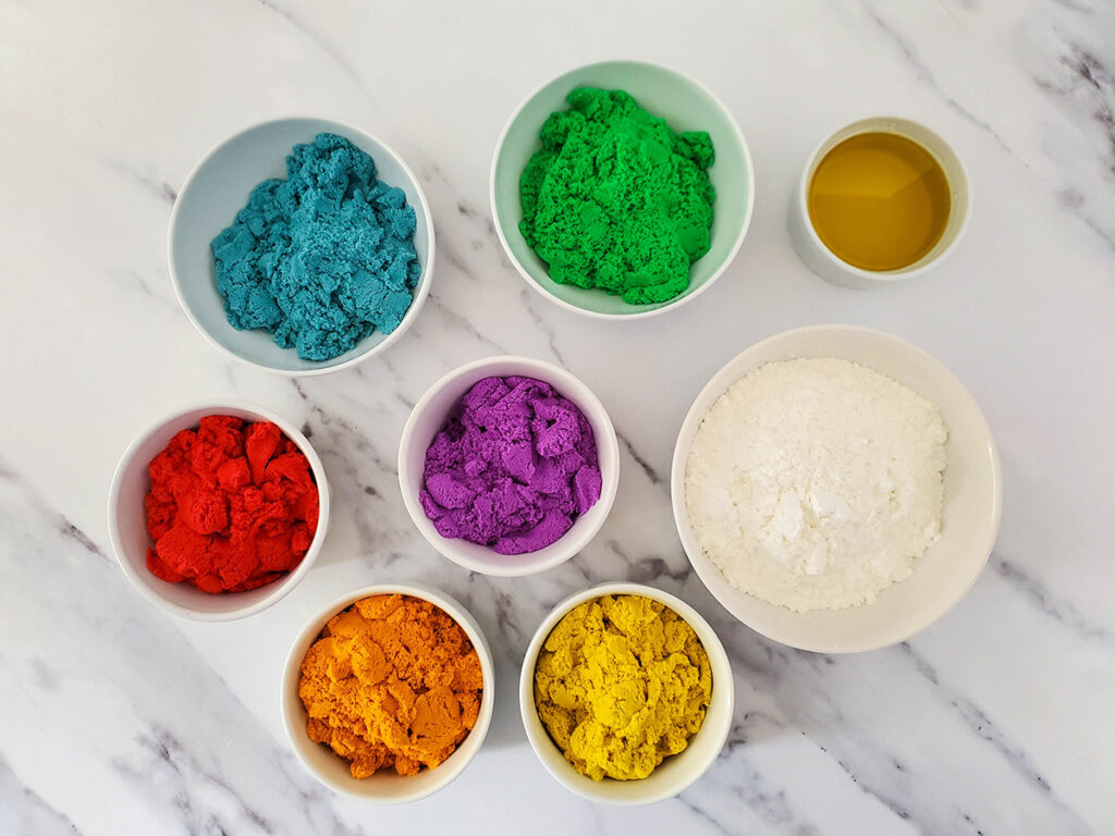 Looking to see how to make kinetic sand? This kinetic sand recipe uses just 3 ingredients to make a soft, moldable sand that provides hours of fun sensory play time for kids!